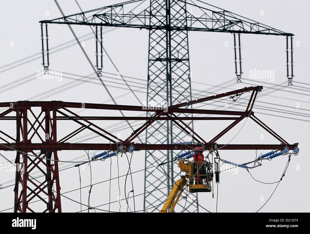 I lavoratori di EnviaM lavorare su un 110.000-volt-linea aerea rotta vicino Espenhain, Germania, 9 gennaio 2013. Essi trasferire i poli per 50-100m ed anche rinnovare la linea di alimentazione a causa di piani di costruzione dell'autostrada (A 72). Foto: Jan Woitas Foto Stock