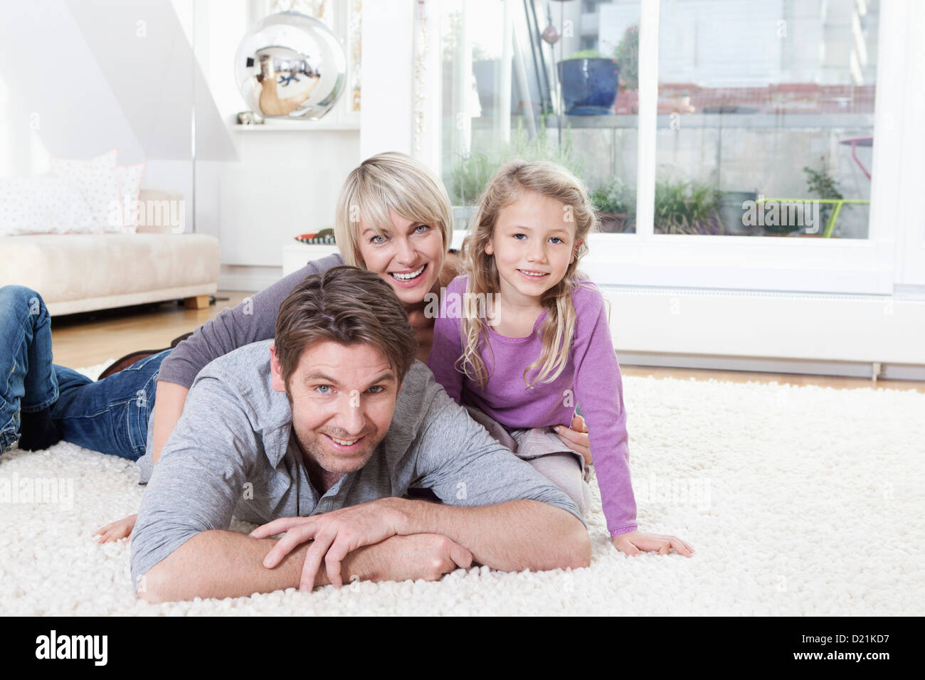 In Germania, in Baviera, Monaco di Baviera, Famiglia giacente sul piano, sorridente, ritratto Foto Stock