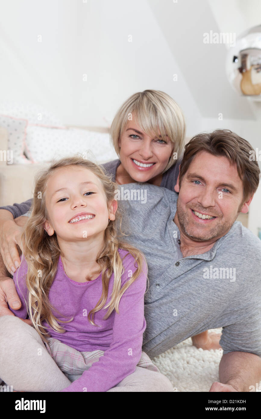 In Germania, in Baviera, Monaco di Baviera, Famiglia giacente sul piano, sorridente, ritratto Foto Stock