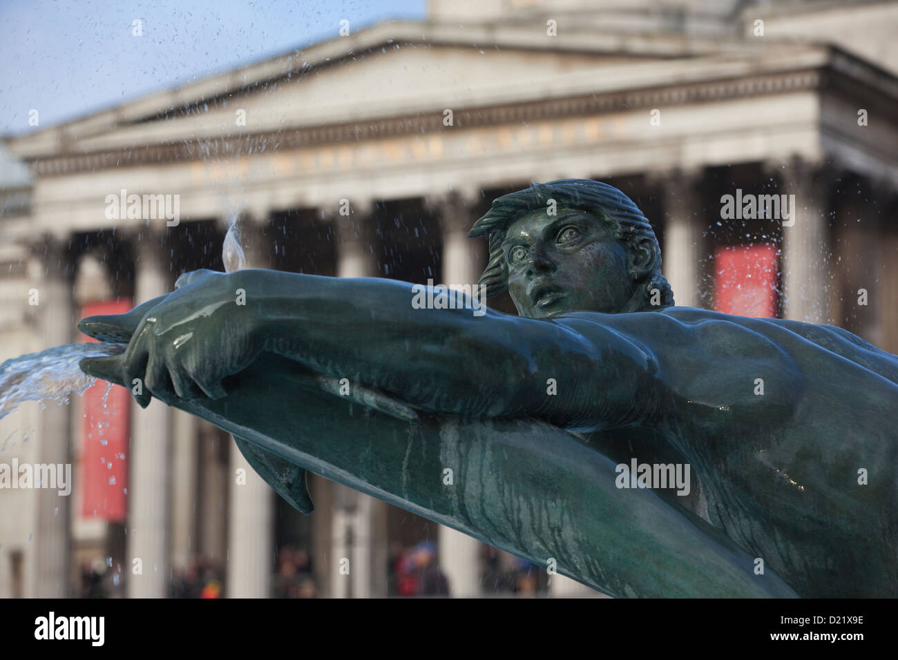 La scultura di un tritone a Trafalgar Square con la National Gallery in background, Central London, England, Regno Unito Foto Stock