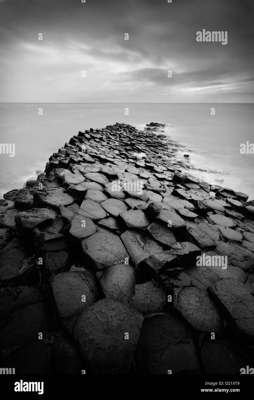 In bianco e nero lunga esposizione sulle rocce e mare presso il famoso Giant's Causeway in Irlanda del Nord Foto Stock