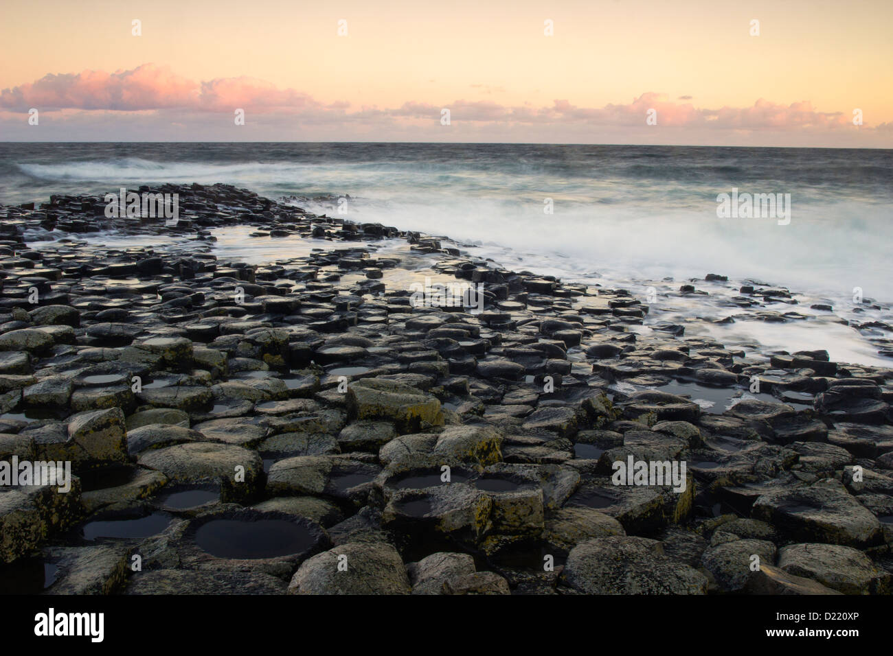 La luce del mattino e forti onde sulla Giant's Causeway - punto di riferimento dell'Irlanda del Nord Foto Stock