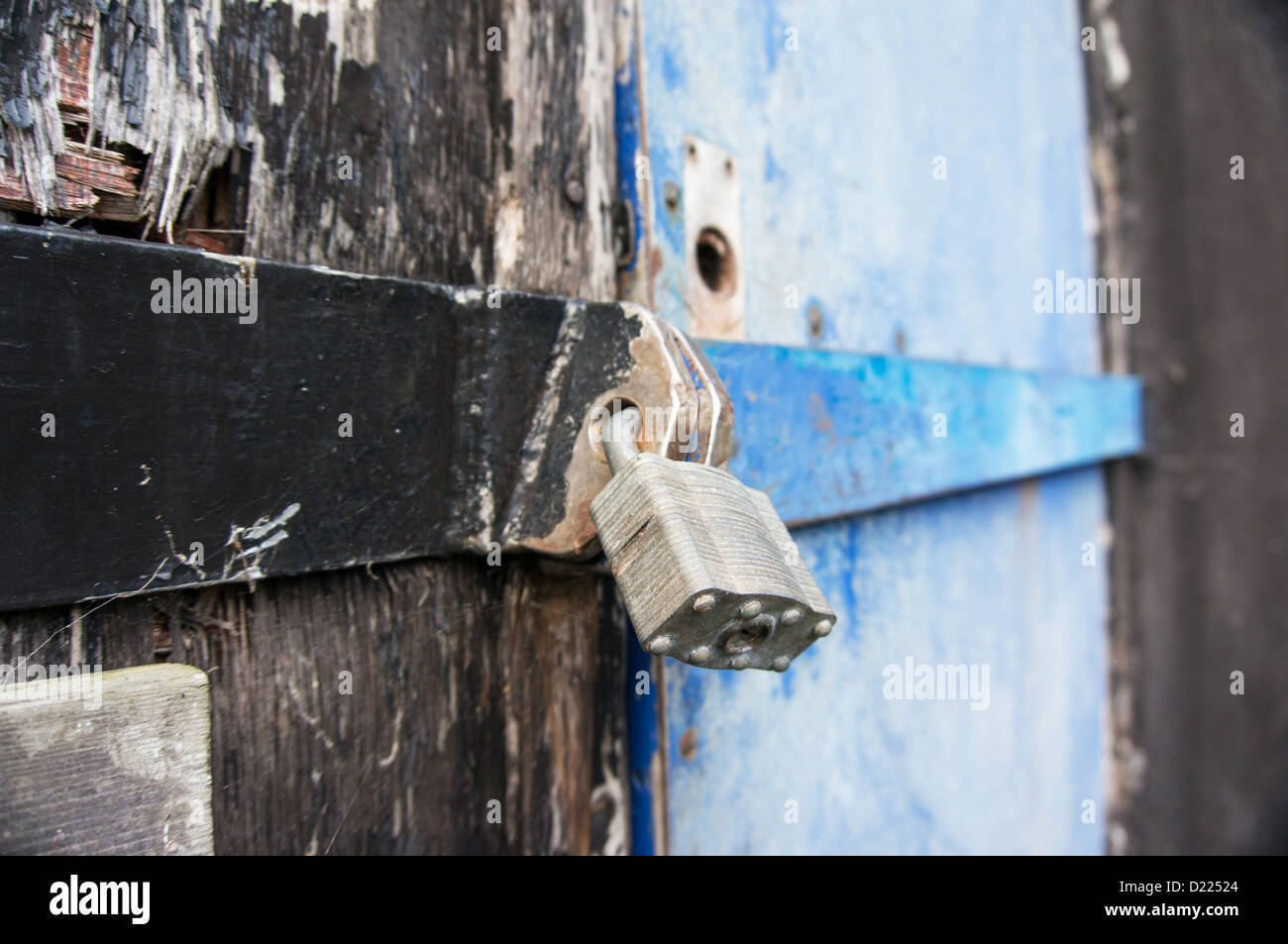 Fissare il lucchetto montato su una porta di un vecchio deposito composto - profondità di campo Foto Stock
