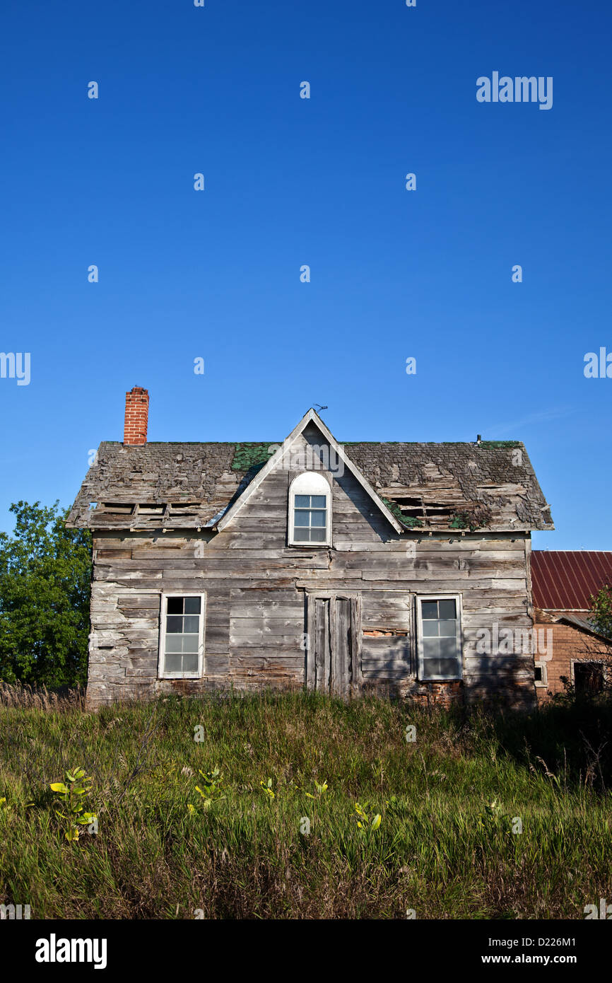 Una vecchia casa diroccata, sfrenatamente incolto visto dalla parte anteriore. Foto Stock