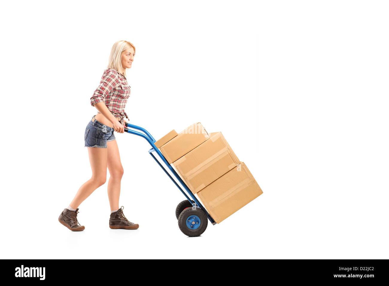 A piena lunghezza Ritratto di un lavoratore di sesso femminile che spingendo un carrello con scatole isolate su sfondo bianco Foto Stock