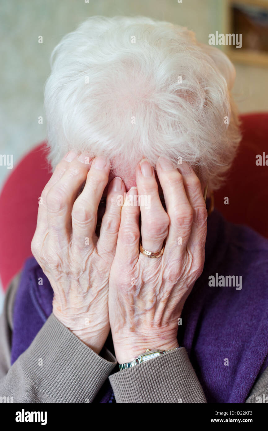 Una donna anziana preoccuparsi di fatture Foto Stock