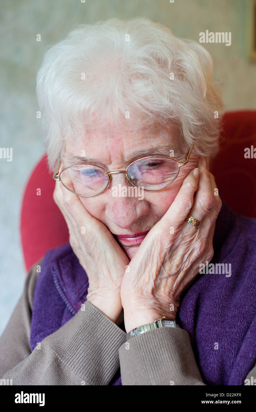 Una donna anziana preoccuparsi di fatture Foto Stock