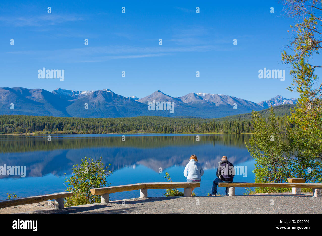 Giovane seduto sulla piramide isola nel Lago Piramide nel Parco Nazionale di Jasper in Alberta Canada Foto Stock