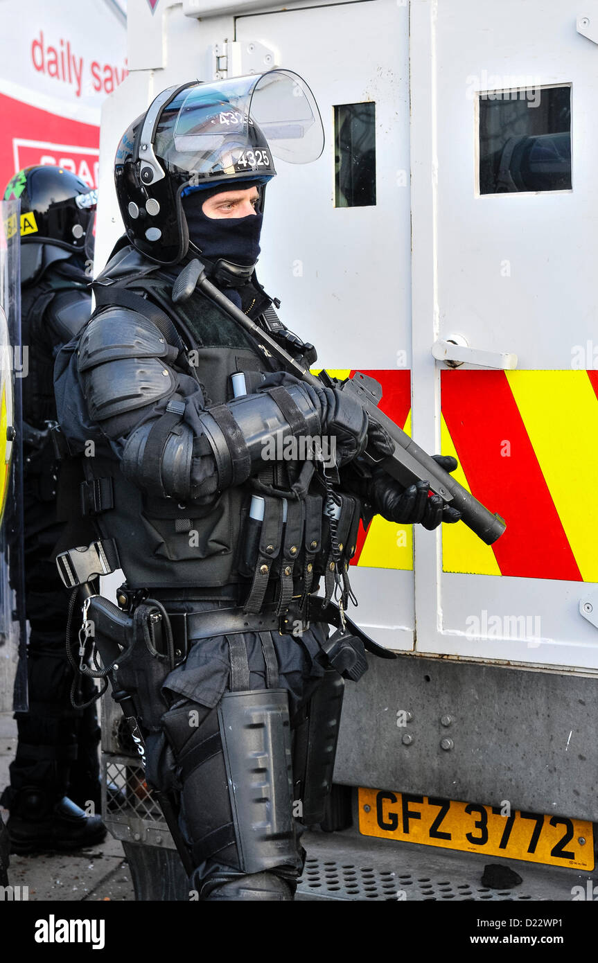Xii Gennaio 2013, Belfast, Irlanda del Nord. Un PSNI TSG ufficiale con un Heckler e Koch L104A1 37mm single-shot AEP (plastica bullet) orologi launcher una folla di dimostranti. Credito: Stephen Barnes / Alamy Live News Foto Stock