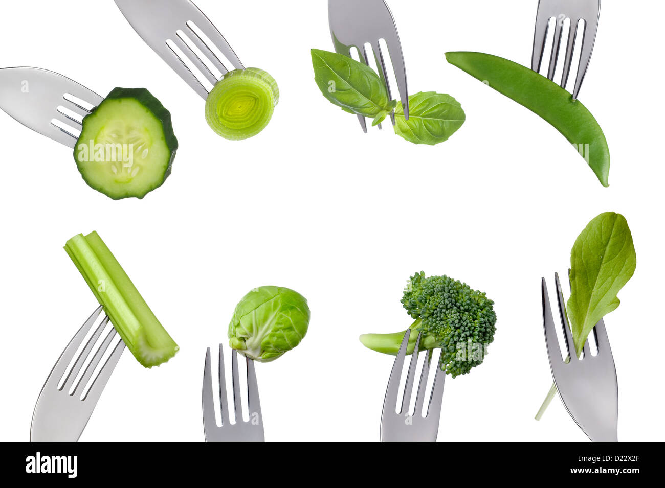 Verde fresco verdure sane su forche isolata contro uno sfondo bianco formando un bordo con spazio di copia Foto Stock