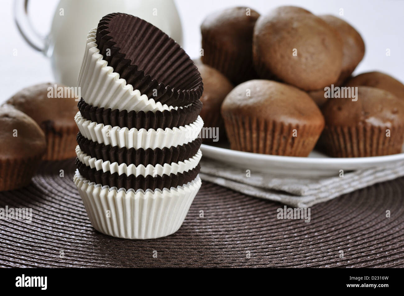 Marrone e bianco cupcake casi con tortini di cioccolato su sfondo scuro Foto Stock