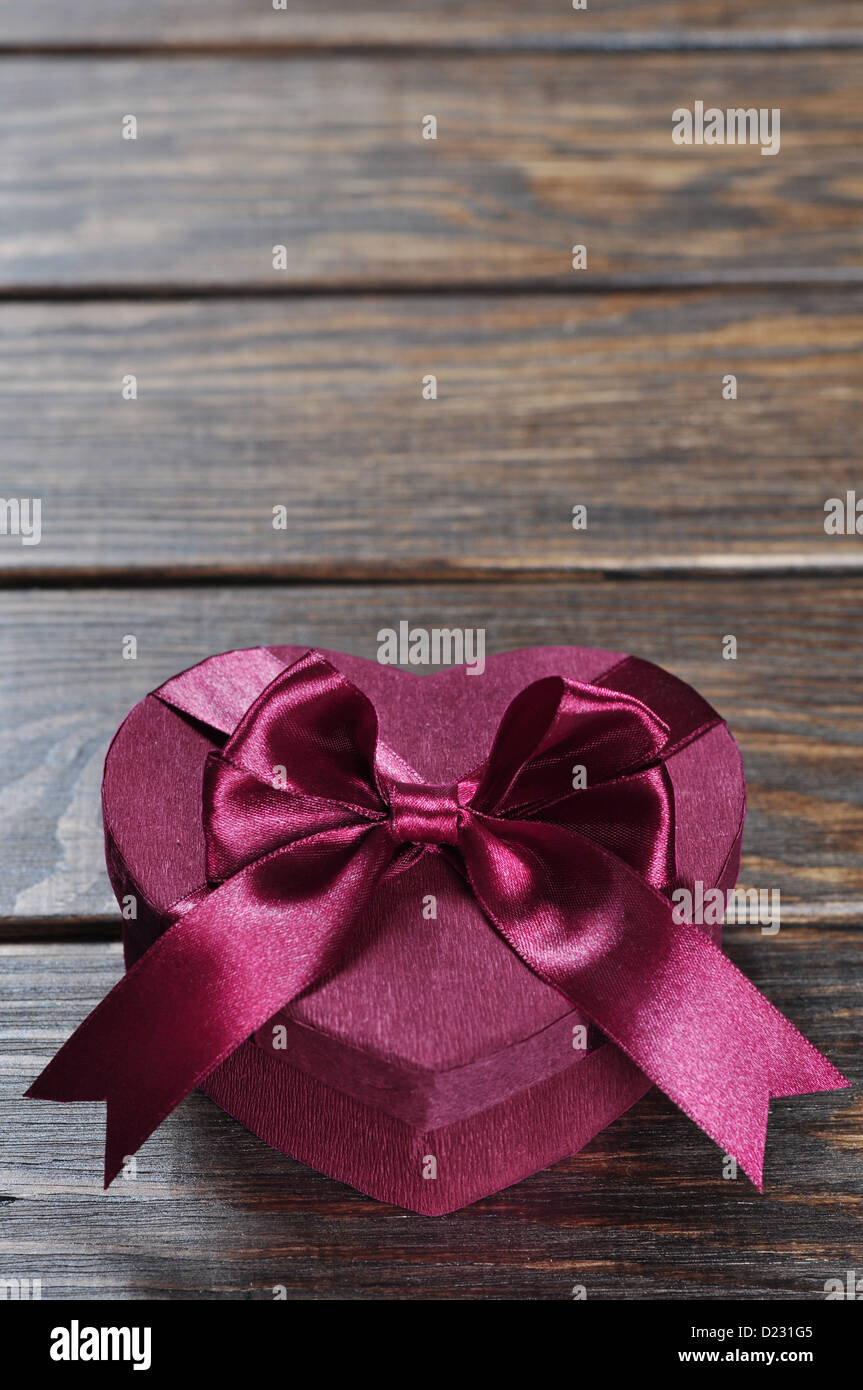 A forma di cuore rosa il giorno di San Valentino confezione regalo su sfondo di legno. Foto Stock