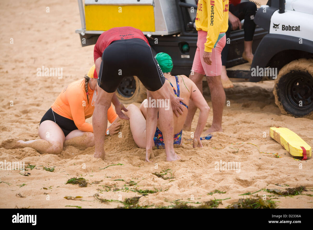 Signora riceve primo aiuto da surf rescue team su Avalon Beach di Sydney Foto Stock