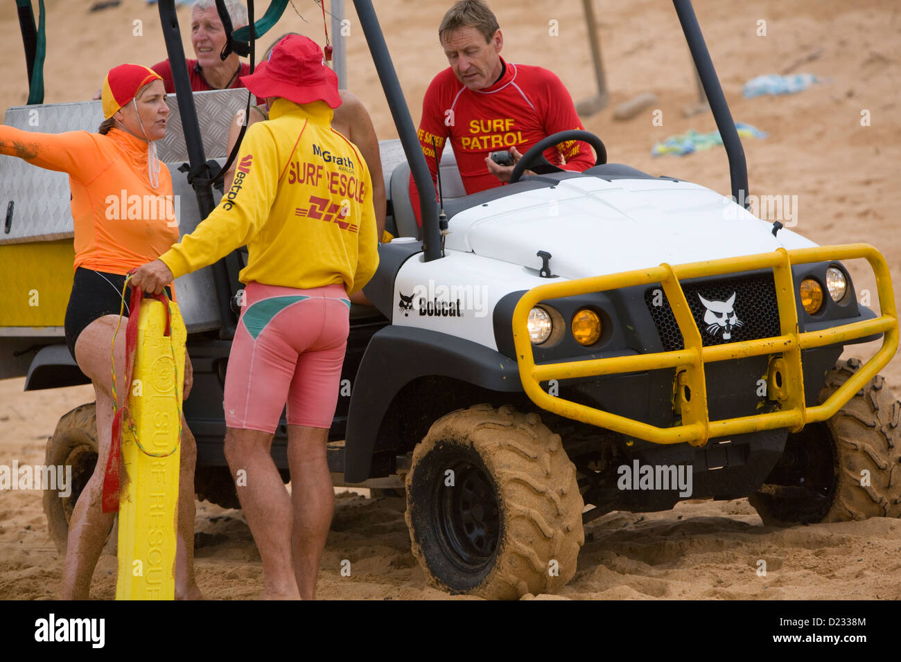 Navigare il personale di soccorso aiutare un ferito signora su una spiaggia di Sydney, Australia Foto Stock