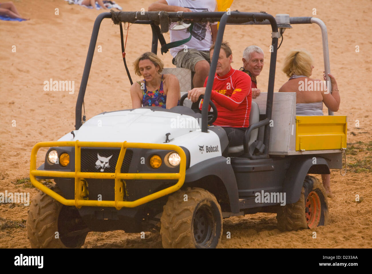 Navigare il personale di soccorso aiutare un ferito signora su una spiaggia di Sydney, Australia Foto Stock