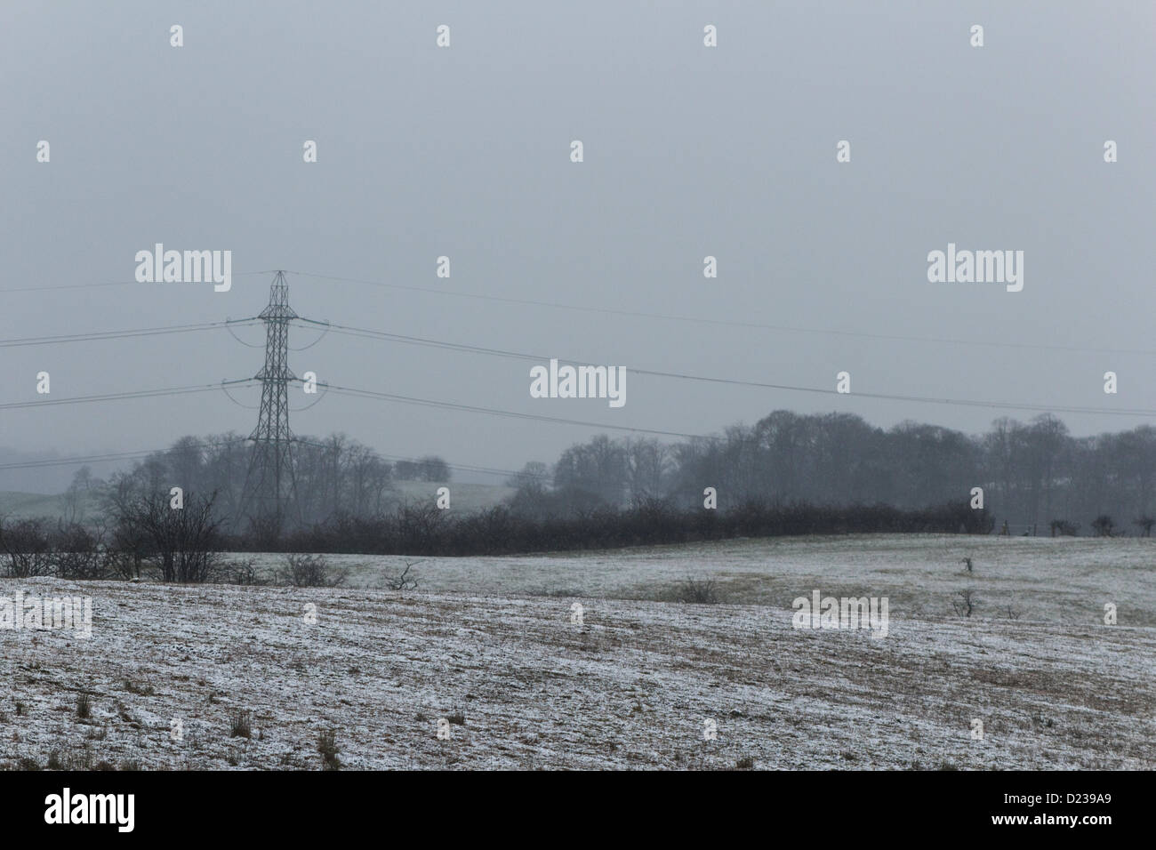 Neve in campi con cieli grigi e un pilone in distanza, Glasgow, Scotland, Regno Unito 2012 inverno. Foto Stock