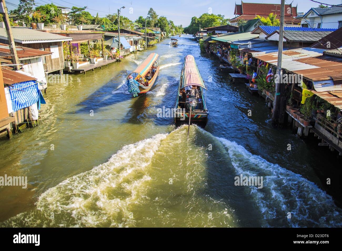 Gen 13, 2013 - Bangkok, Thailandia - Imbarcazioni navigare Khlong (Canale) Bang Luang in Bangkok. Il colpaccio Luang linee di quartiere Khlong (Canale) Bang Luang in Thonburi sezione di Bangkok sul lato ovest del fiume Chao Phraya. Essa è stata fondata alla fine del XVIII secolo da re Taksin il grande dopo il birmano saccheggiata la capitale Siamese di Ayutthaya. Il quartiere, come la maggior parte di Thonburi, è relativamente sottosviluppato e ancora criss attraversato da canali che una volta reso famoso di Bangkok. Ora è un famoso giorno di viaggio dal centro di Bangkok e ti offre un assaggio di ciò che la città ha usato essere simili. (Credi Foto Stock