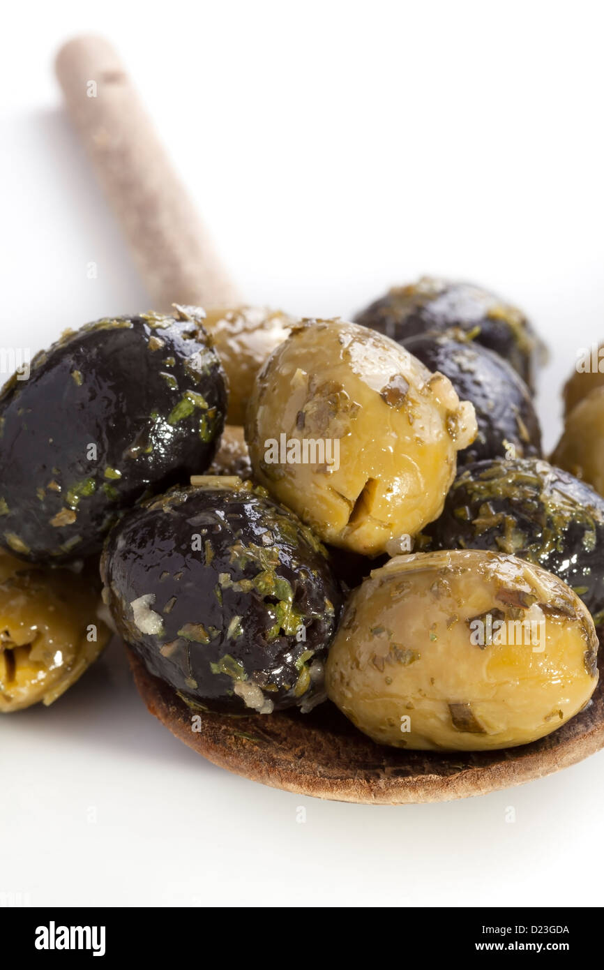 Verde e olive nere sul cucchiaio di legno Foto Stock