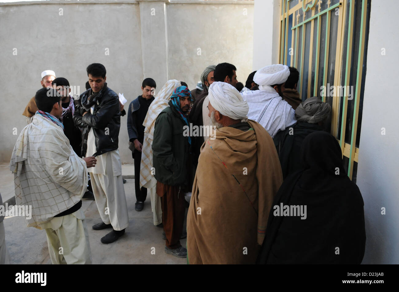 Gli uomini afghani attendere per poter parlare con un tecnico presso il Farah città comune uffici nella città di Farah, gen. 13. Provincial Reconstruction Team (PRT) Farah leadership si è incontrato con il signor sindaco per la prima volta dal suo insediamento, e discusso la governance e sviluppo socioeconomico questioni e iniziative in comune. PRT Farah ha la missione di treno, consigliare e assistere il governo afgano leader a livello comunale, distretto e i livelli provinciali nella provincia di Farah in Afghanistan. Il civile squadra militare è composta di membri dell'U.S. Navy, U.S. Esercito, U.S. Dipartimento di Stato degli Stati Uniti e gli Stati Uniti Un Foto Stock