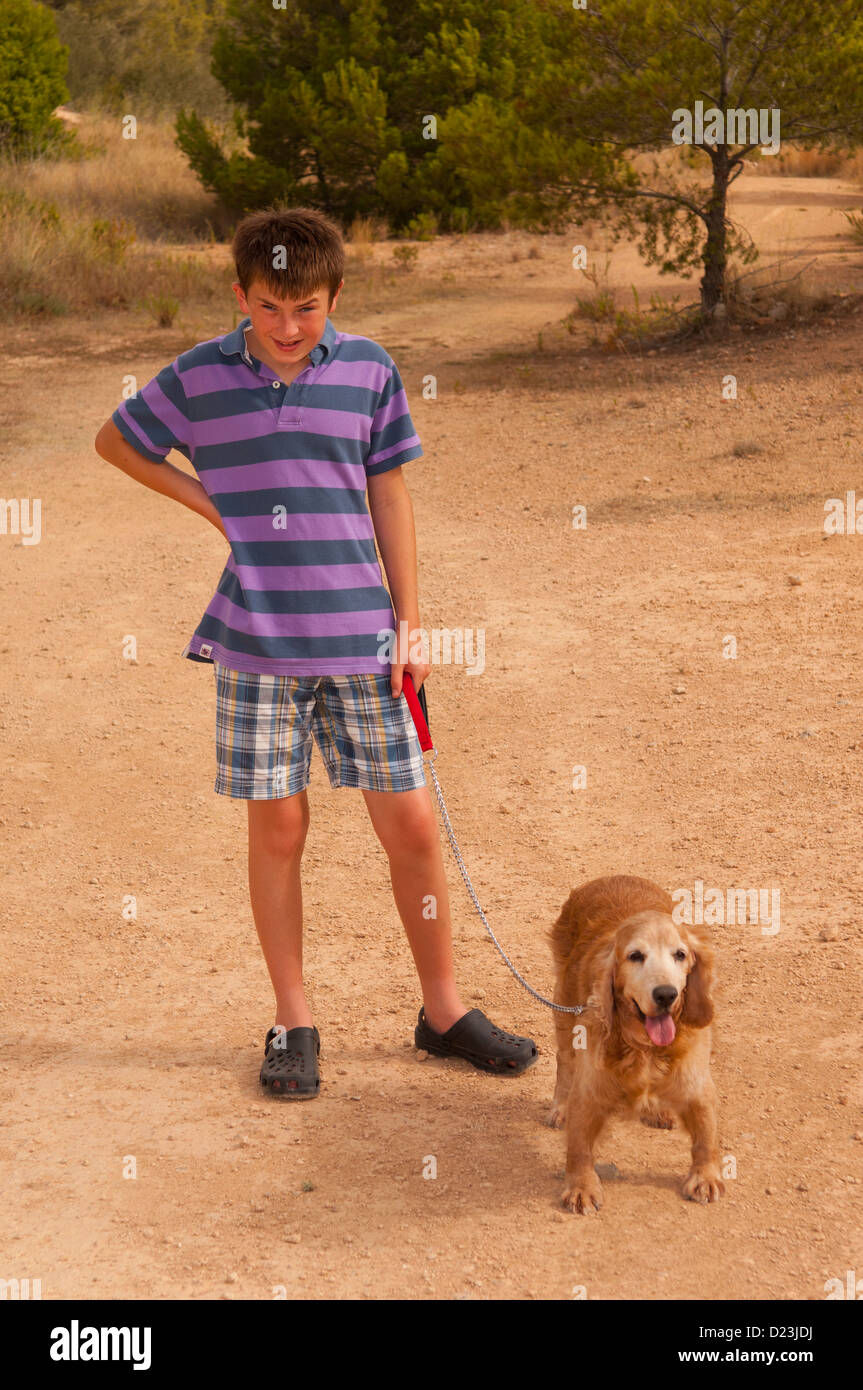 Un dodicenne ragazzo di camminare un cocker spaniel cane in Spagna Foto Stock