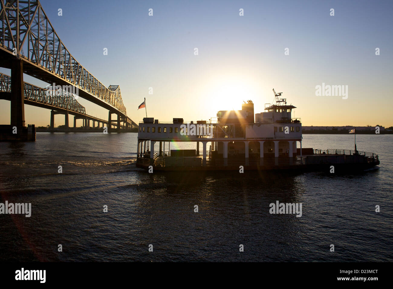 Tramonto sul fiume Mississippi a New Orleans, Louisiana, con traversata in traghetto sotto il ponte Crescent City Connection Foto Stock