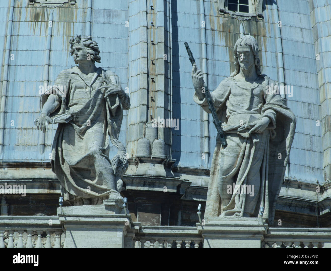 Le statue di San Giovanni Evangelista e San Giacomo il giovane sulla facciata della basilica di San Pietro fanno parte del patrimonio architettonico della chiesa. Queste sculture aggiungono un significato storico e religioso all'iconica struttura del Vaticano. Foto Stock