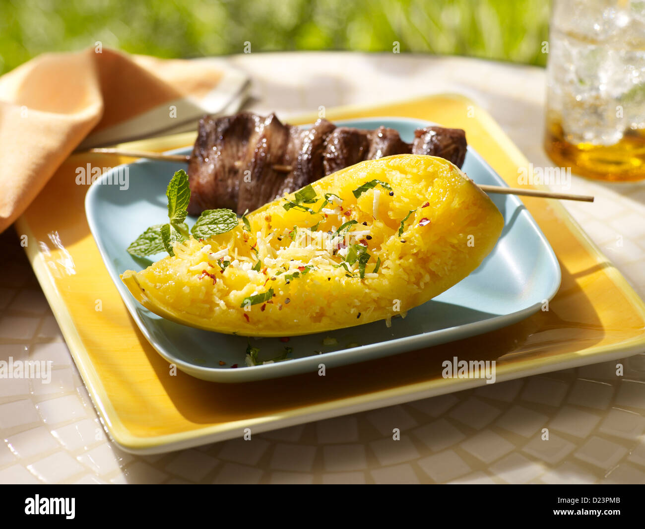 Zucca spaghetti serviti con spiedino di carne in un dehor estivo impostazione Foto Stock