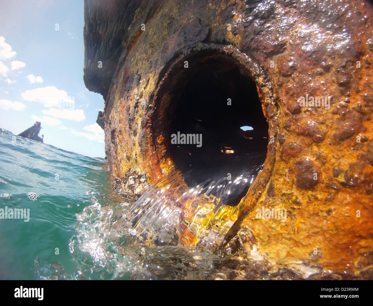 Versare acqua di mare da oblò della nave naufragata come si gonfiano passa da relitti di Tangalooma, Moreton Bay Marine Park, Australia Foto Stock
