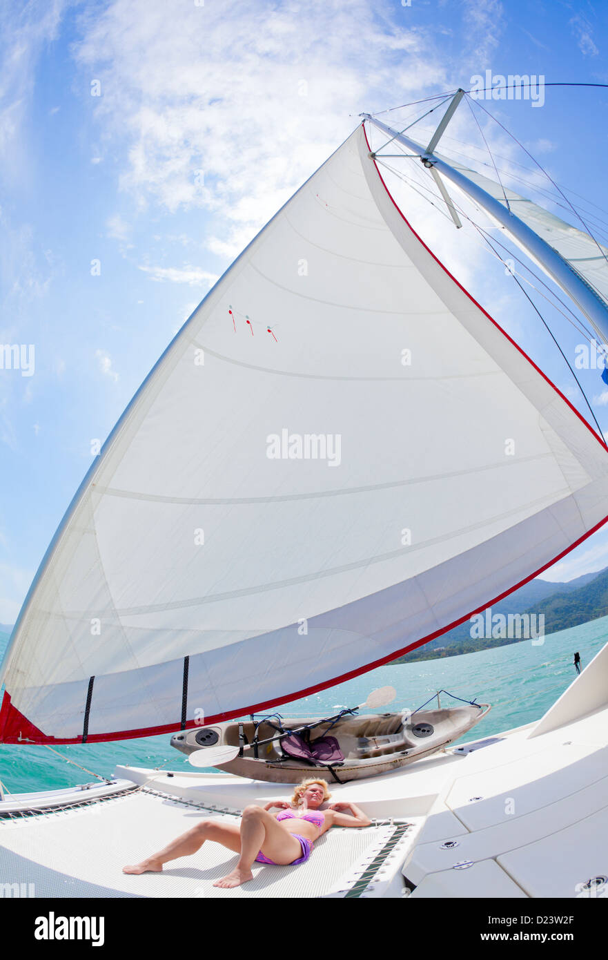 Prendere il sole sul ponte di una barca a vela Foto Stock