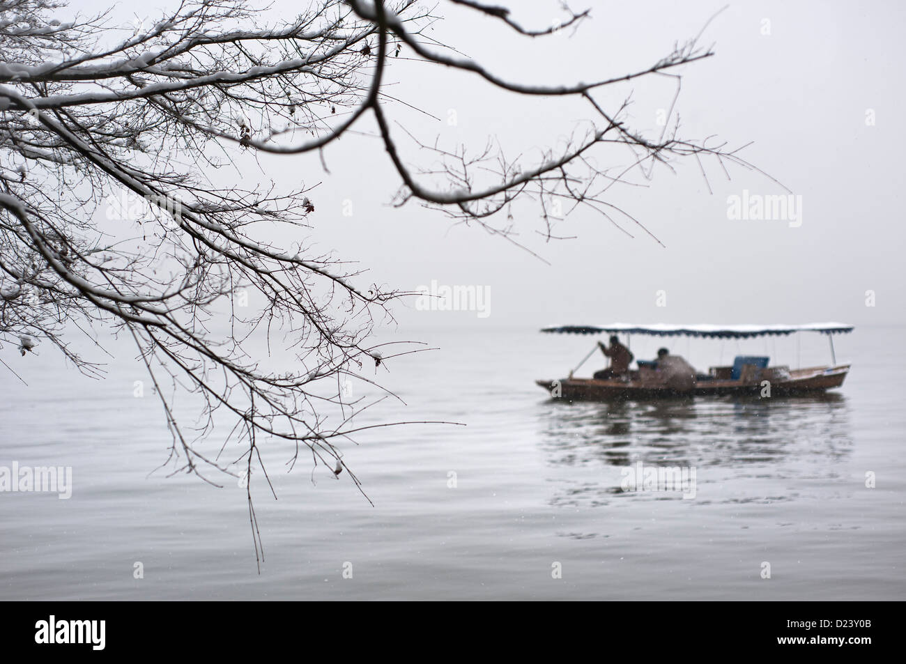 Barca a remi e il ramo a West Lake in inverno, Hangzhou Foto Stock