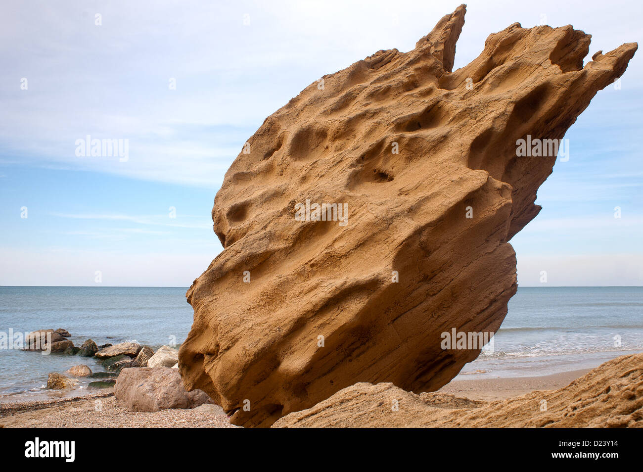 Grande pietra arenaria calcarea boulder su una spiaggia tranquilla Foto Stock