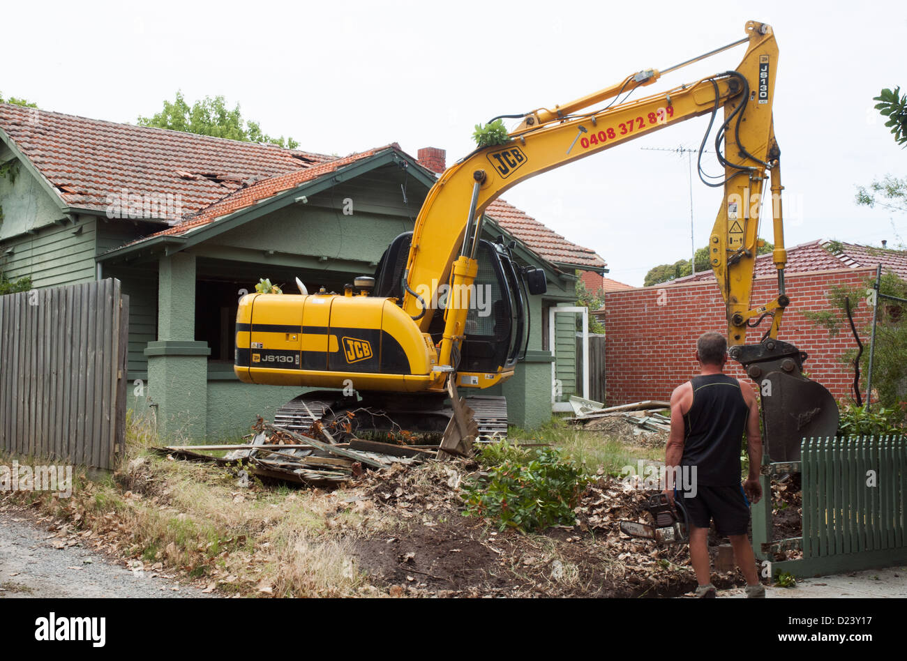 Un imprenditore si prepara a cominciare la demolizione di un 1920s 'californiano " Bungalow casa di legno nella periferia di Melbourne, Australia Foto Stock