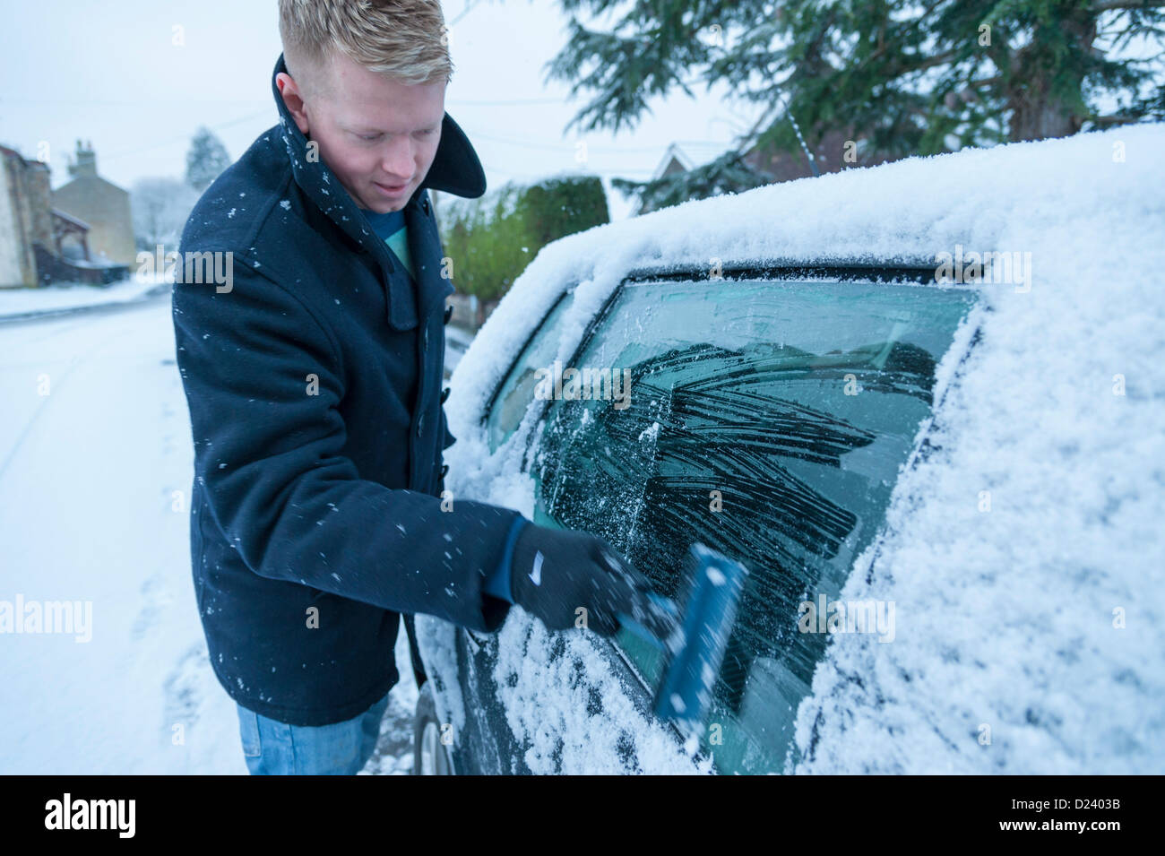 Cambridge, Regno Unito. 14 gennaio 2013. Joe Gilson raschia la neve per tutta la notte dalla sua auto all'inizio del suo tragitto al lavoro a Cambridge Regno Unito 14 gennaio 2013. Il primo significativo neve dell'inverno cadde la notte scorsa su East Anglia e gran parte del Regno Unito. Più pesante è la neve previsioni dal mezzo di oggi che è suscettibile di causare interruzioni di viaggio per molte persone Credito: Julian Eales / Alamy Live News Foto Stock