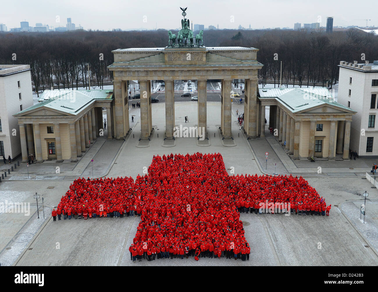 1.800 membri della Croce Rossa tedesca (DRK) vestita in rosso formano una grande croce alla Porta di Brandeburgo a Berlino, Germania, 13 gennaio 2013. La performance è parte di questo anno il centocinquantesimo anniversario. Foto: Britta Pedersen Foto Stock