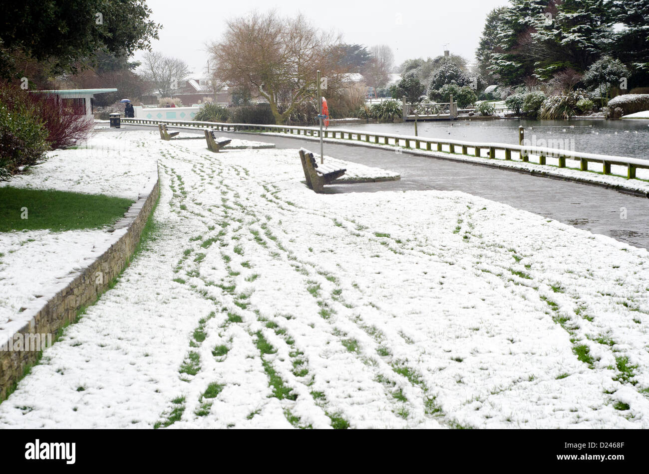 Impronte in un parco dopo una leggera nevicata in inverno nel Parco Mewsbrook, Littlehampton, West Sussex, in Inghilterra, Regno Unito. Foto Stock