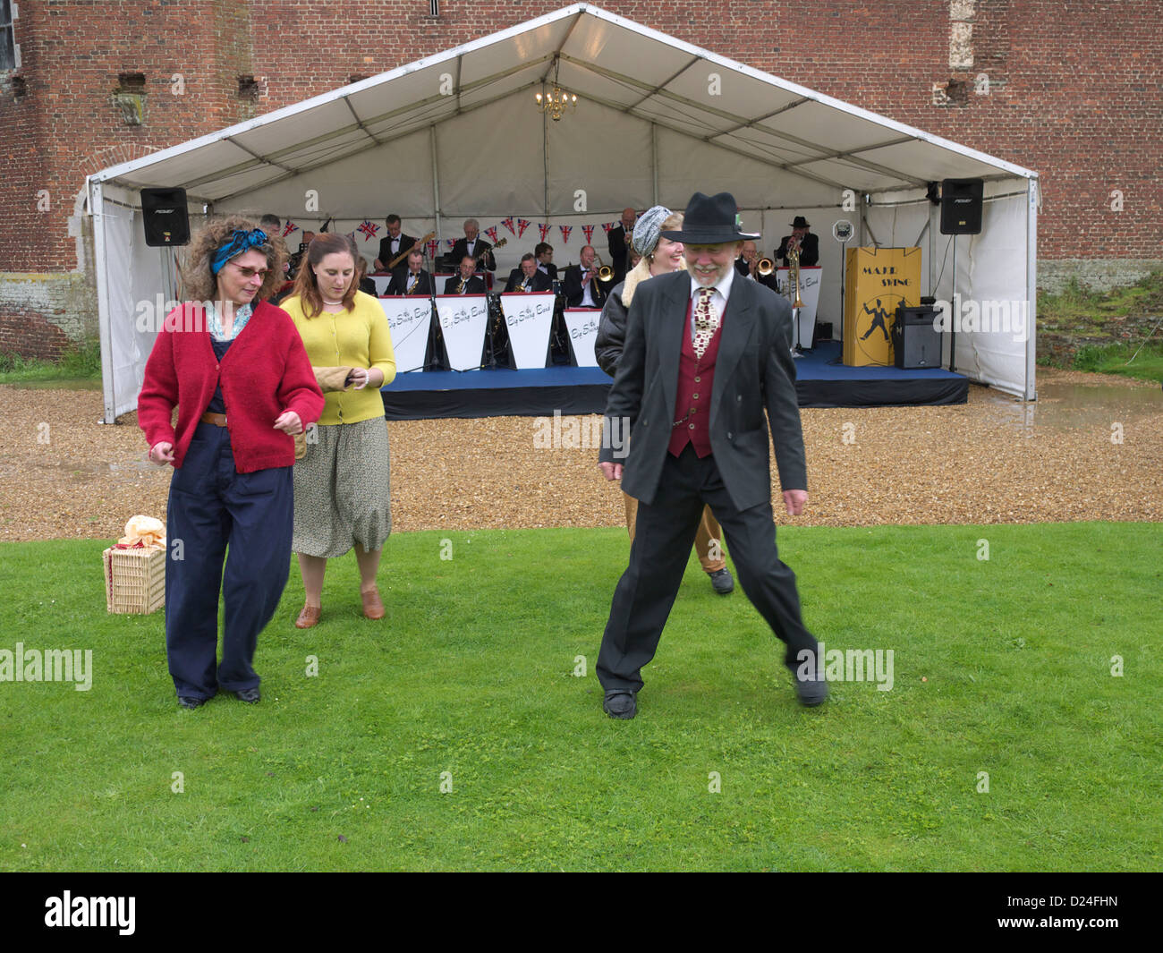 1940 re-enactors Wendy, Ray, Amanda e amico ballando sotto la pioggia a Tattershall Castle 1940's day Foto Stock