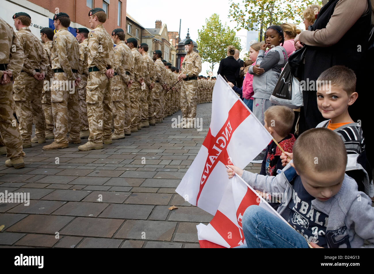 Un bambino sventola una bandiera nazionale a un welcome home sfilata di soldati britannici di ritorno dall' Afghanistan. Foto Stock