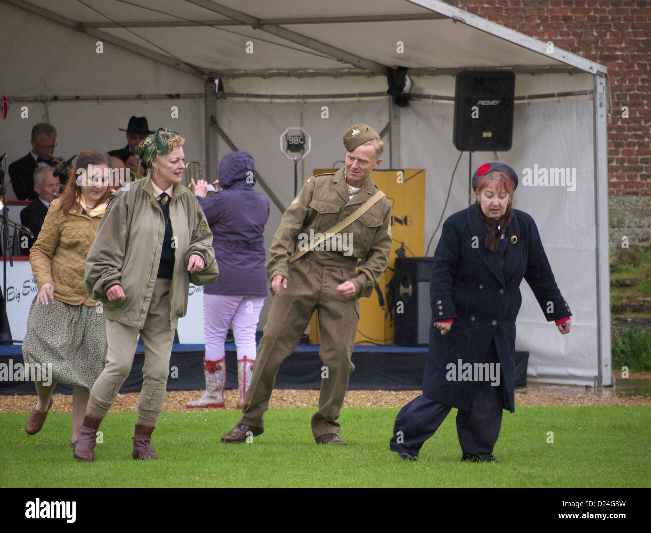 1940 re-enactors ballando sotto la pioggia a tattershall castle 1940's day Foto Stock