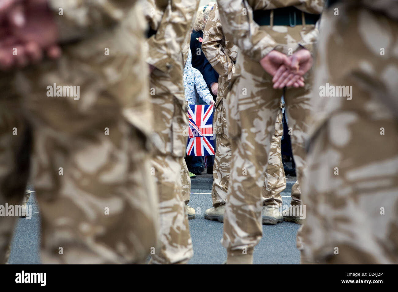Un Union Jack flag visto dietro le gambe dei soldati britannici. Foto Stock