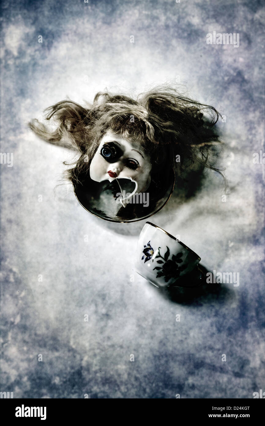 La testa di un vecchio, Broken Doll su un piattino con una tazza di tè Foto Stock