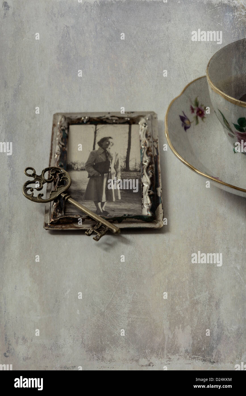 Una tazza di caffè con una vecchia foto e una vecchia chiave Foto Stock