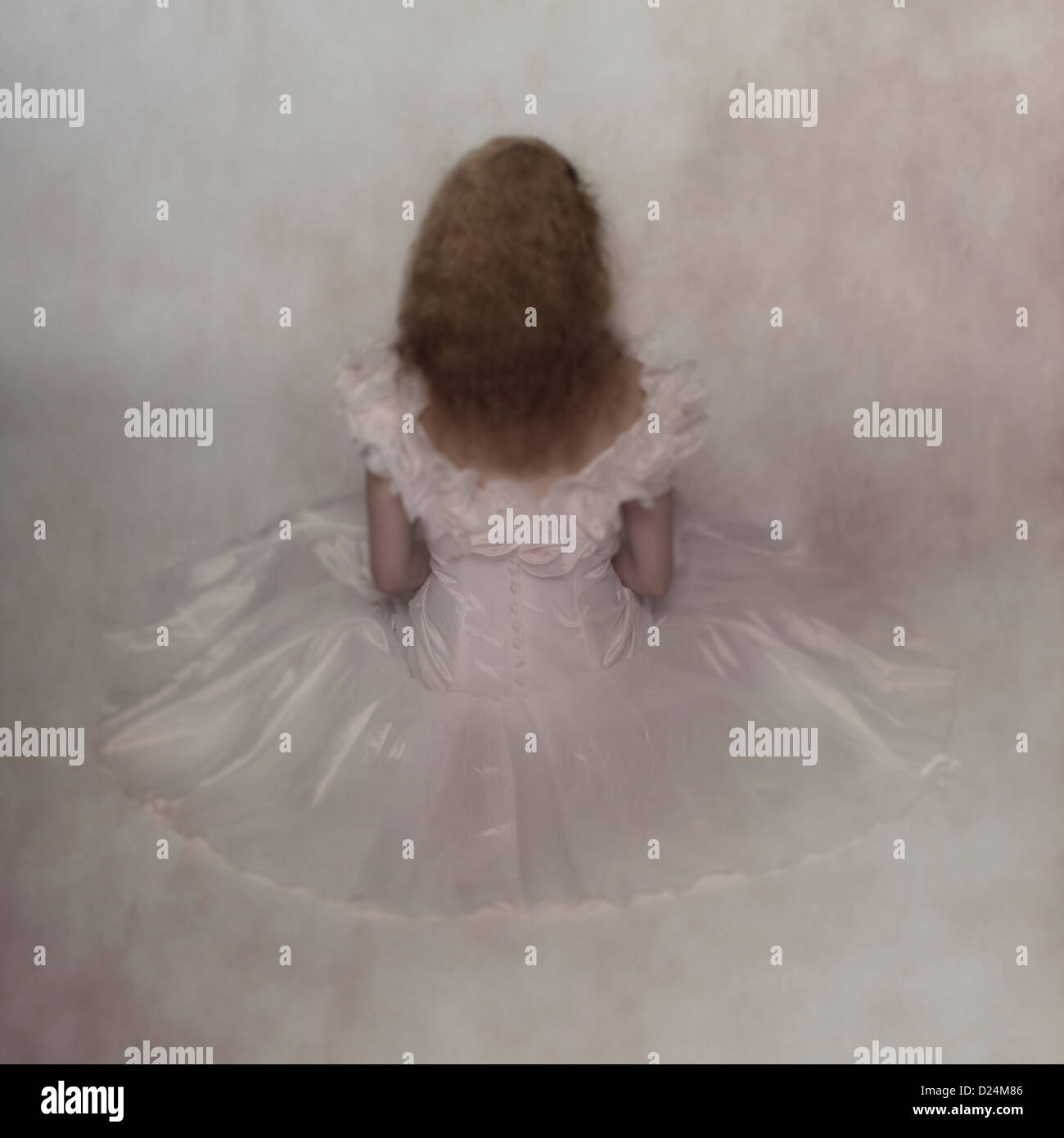 Una donna in un bianco abito nuziale è seduta sul pavimento Foto Stock