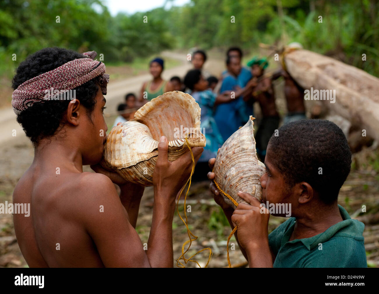 Ragazzi che soffia in gusci, Alotau, Milne Bay, provincia di Papua Nuova Guinea Foto Stock