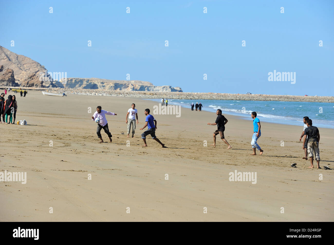 Giocare a calcio sulla vasta distesa di spiaggia di sabbia a Yiti; Muscat Oman. Foto Stock