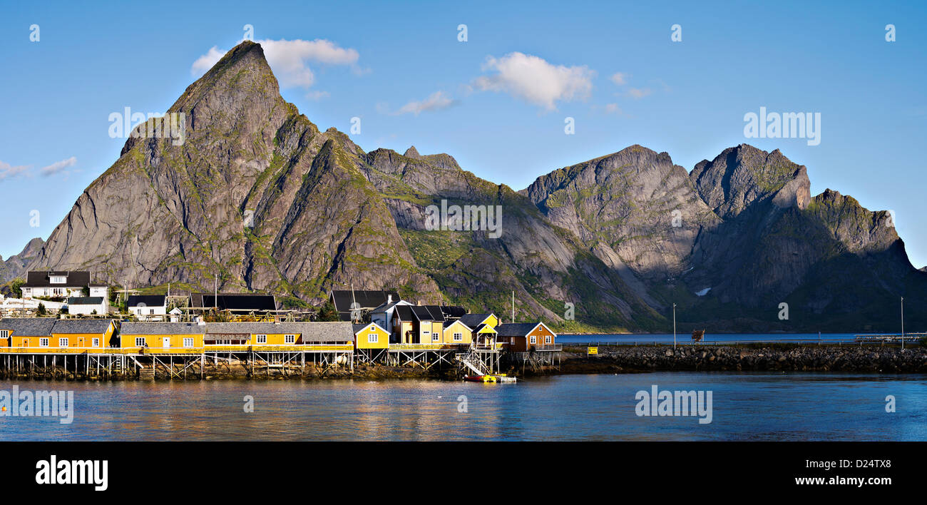 Cabine e magazzini a Sakrisoy nei sotto il picco di Olstinden, Lofoten, arctic Norvegia Foto Stock