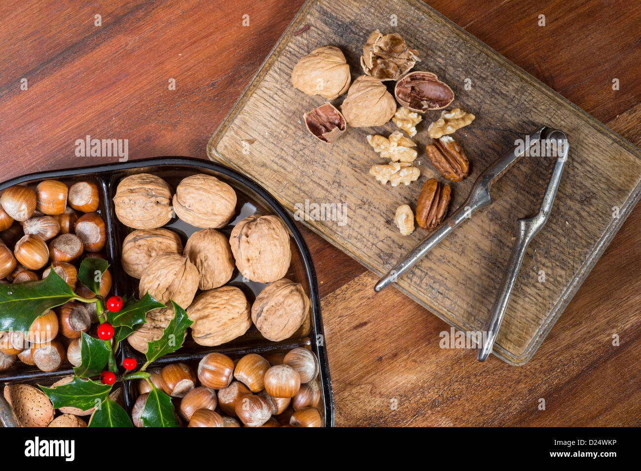 I dadi commestibili e schiaccianoci su un tavolo a casa in una impostazione di Natale; Regno Unito Foto Stock