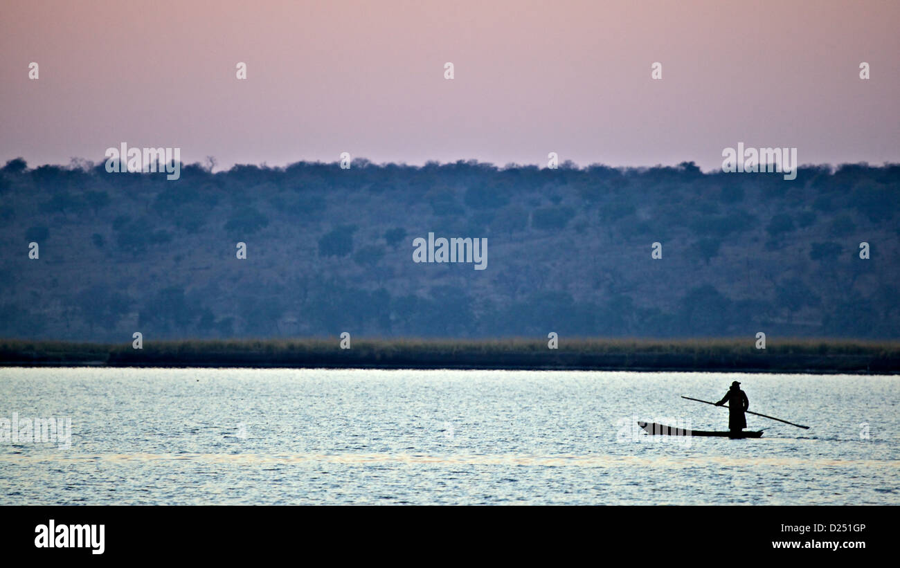 Makoro canoa stagliano al tramonto, Chobe N.P., Botswana, Luglio Foto Stock