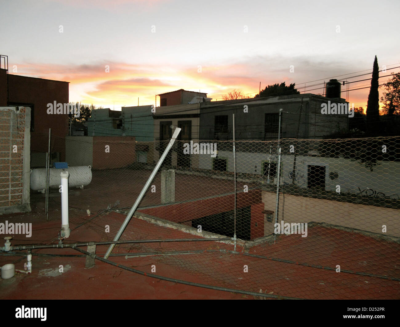 Ordinaria tetto utilitaristica in Oaxaca de Juarez al tramonto con vista superba del persistente al tramonto colori edifici delineato il Messico Foto Stock