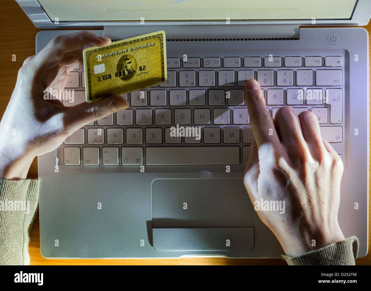 Utilizzo di una carta di credito in Internet, digitando il numero della carta di credito sulla tastiera di un computer. Foto Stock