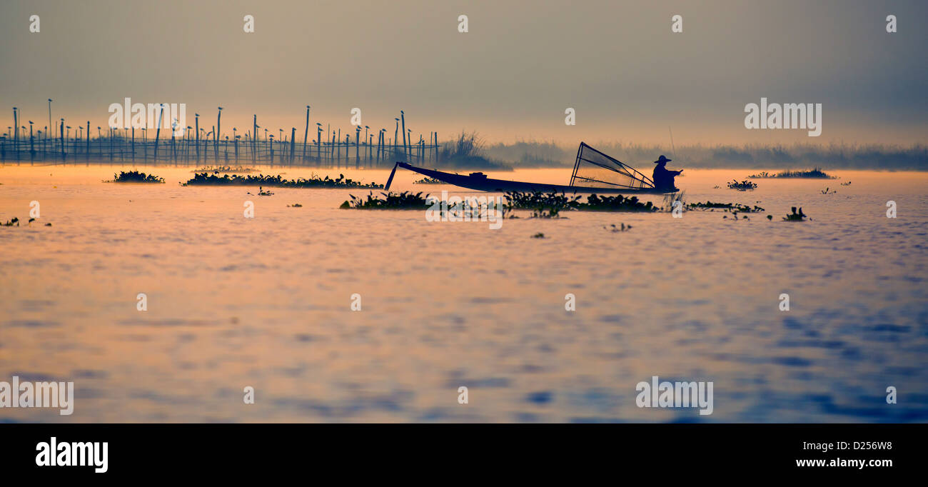 La pesca mentre il bilanciamento con le gambe, inle, MYANMAR Birmania Foto Stock